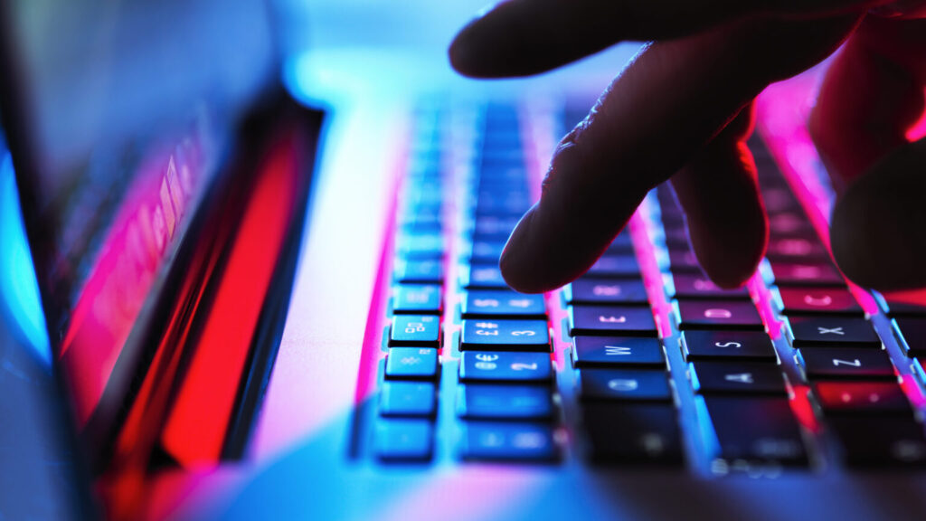Man typing at his laptop computer at night